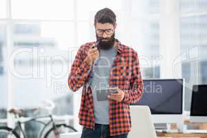 Hipster using tablet while standing