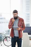 Hipster using tablet while standing