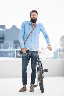 Hipster walking his bike