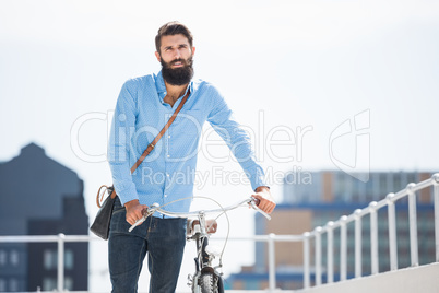 Hipster walking his bike