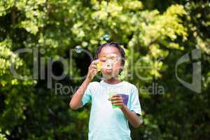 A little boy blowing bubbles