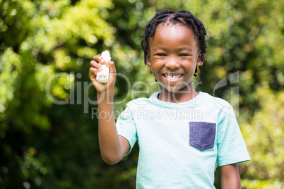 Boy showing his asthma inhaler