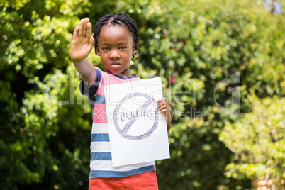 Boy saying stop with hand and paper