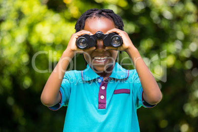 Smiling boy using magnifying glass