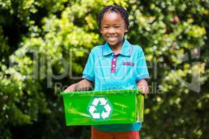 Smiling boy holding a recycling box
