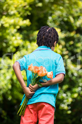 Rear view of a kid hiding bouquet behind back