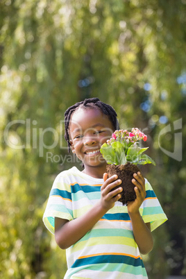 Smiling boy holding a plant