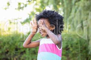 A kid putting her hands like glasses