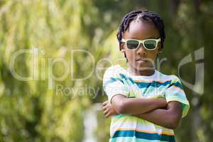 A kid with sunglasses crossing his arms