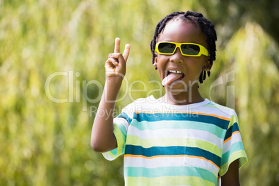 A kid with sunglasses making faces