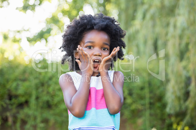 A kid surprised and holding her head in hands