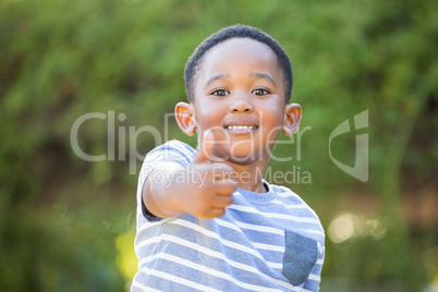 Portrait of cute boy smiling with thumbs up