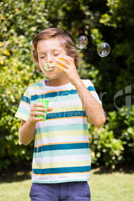 A little boy is making bubble