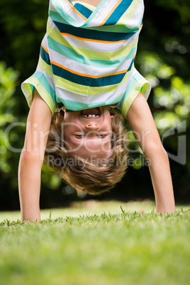 A little boy is playing upside down