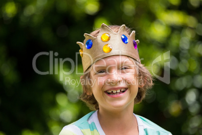 A little boy is holding a crown