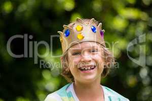 A little boy is holding a crown