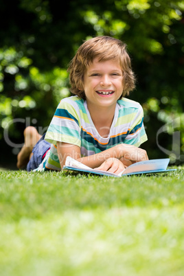 A little boy is lying down in the grass