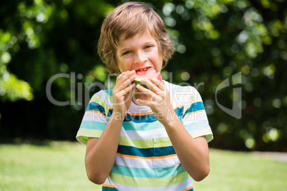 A little boy is eating a watermelon