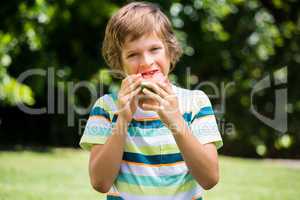 A little boy is eating a watermelon