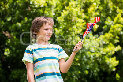 A little boy is holding an american flag