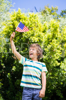 A little boy is holding an american flag