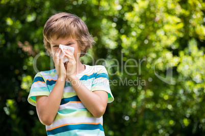 A little boy is blowing ones nose