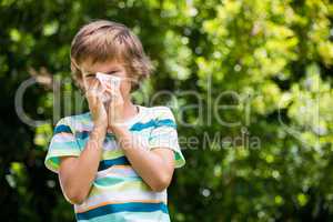 A little boy is blowing ones nose