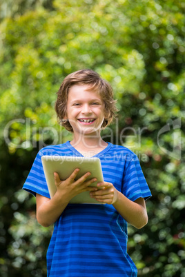 A little boy is smiling with a tablet computer