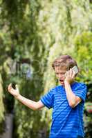 A little boy is angry with his mobile phone