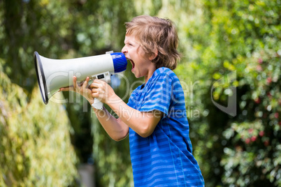 A little boy is screaming with a megaphone