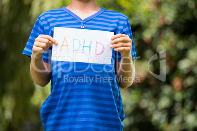 Portrait of young boy holding a message
