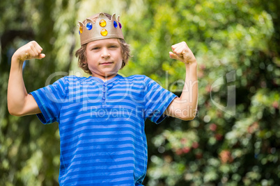Cute boy with a crown showing his muscles