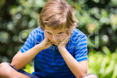 Portrait of cute boy sitting and sulking