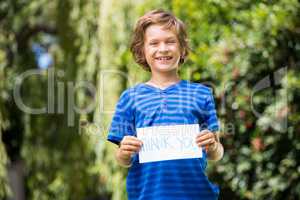 Cute boy smiling and holding a message