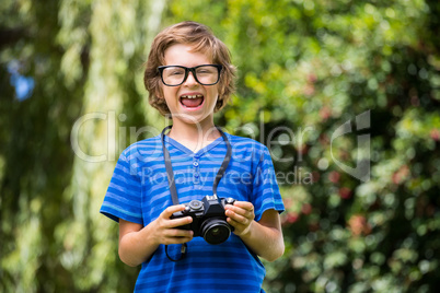 Cute boy with glasses holding a camera