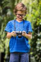 Cute boy with glasses holding and looking a camera