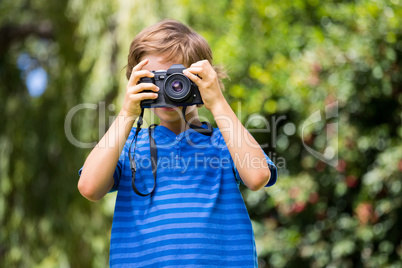 Portrait of young boy taking a photo face to the camera