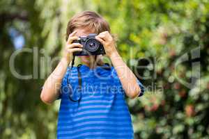 Portrait of young boy taking a photo face to the camera