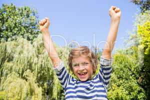 Portrait of happy boy raising arms