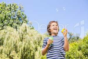 Cute boy smiling and playing with bubbles