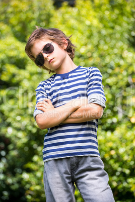 Cute boy with sunglasses posing with crossed arms