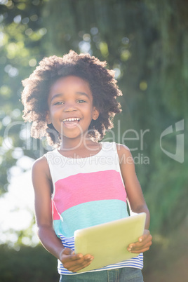 Portrait of cute boy smiling and holding a tablet