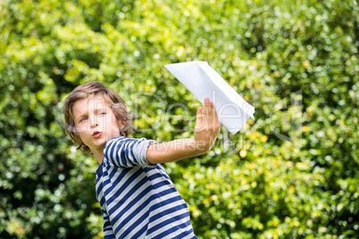 Portrait of cute boy playing with a paper plane