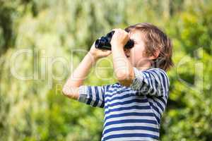 Portrait of cute boy looking something with binoculars