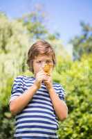 Portrait of cute boy looking a leaf with magnifying glasses