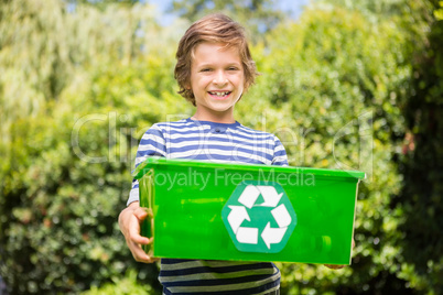 Portrait of cute boy smiling and holding a recycling box