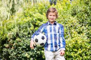 Portrait of cute boy smiling and holding a soccer ball