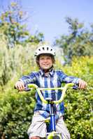 Portrait of cute boy smiling and posing on his bike
