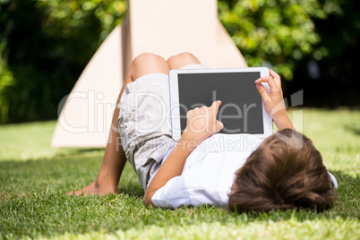 A kid is lying with a tablet computer