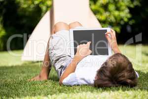 A kid is lying with a tablet computer